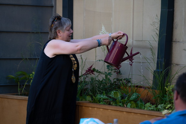 Hebden Royd Mayor Carol Stow 'opens' the scheme by watering a rain garden planter using its monitoring system