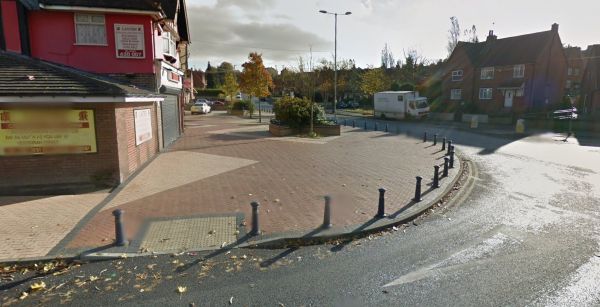 Image of a wide paved plaza outside a row of shops